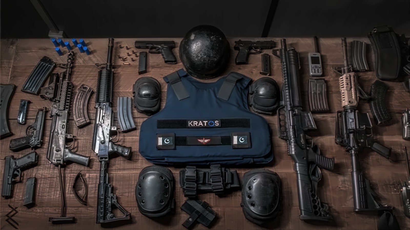 KRATOS duty equipment laid out: ballistic helmet, KRATOS body armour, pads, sidearms, rifles, magazines and communication device